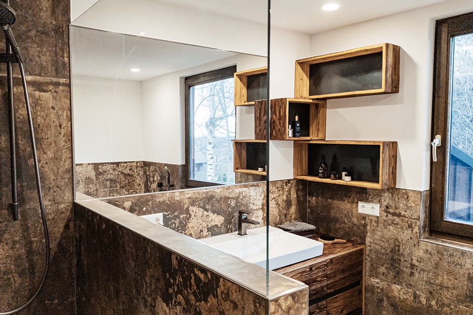 Badmöbel aus Altholz und Schwarzstahl passen sich perfekt in das eh schon markante Badezimmer ein. 