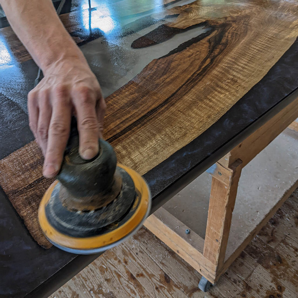 Holztisch mit Epoxidharz Tischplatte polieren
