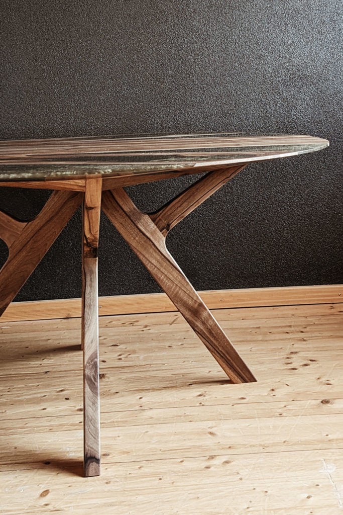 Der runde Epoxidharztisch von Liebwerk hat ein handgefertigtes Tischgestell aus Nussbaum Massivholz.
