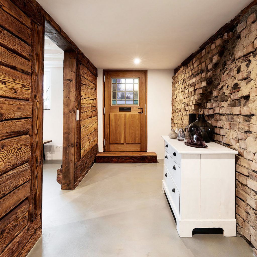 Imposanter Eingangsbereich in altem Bauernhaus mit Balkenwand und Vintage Haustüre von Liebwerk Schreinerei am Bodensee.