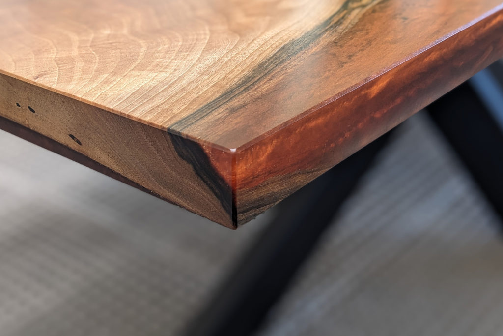 Tolles Kantendetail am Esstisch aus Nussbum und Rusty Glow Epoxidharz