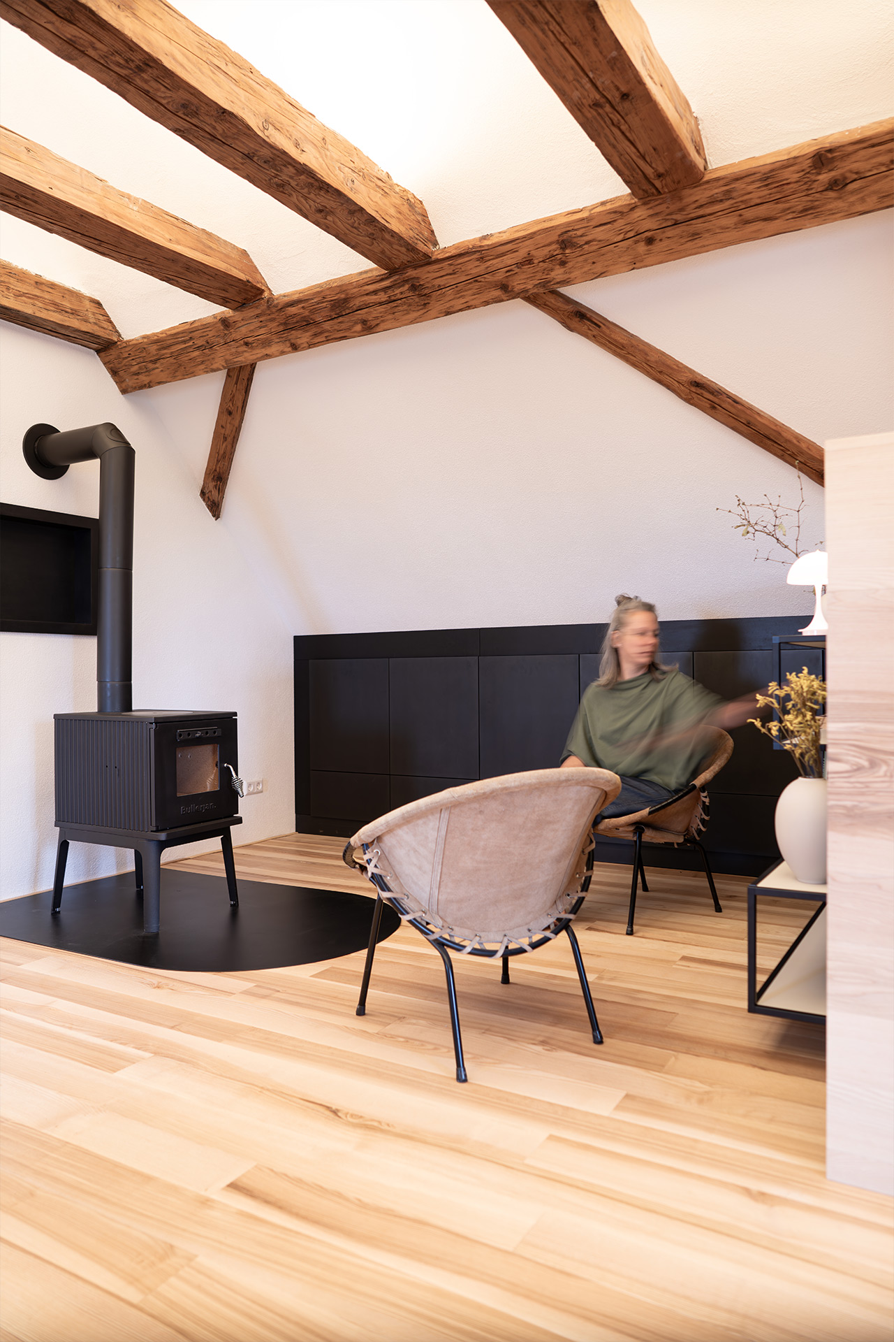 Die dunklen Materialien machen aus der Leseecke im Kaminzimmer einen gemütlichen Rückzugsort.