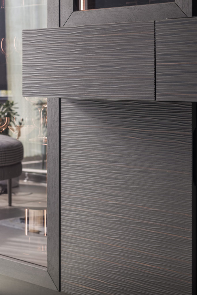 Bronzeglas und Wellenstruktur geben der Vitrine mit Espressobar ein einzigartiges Design. 