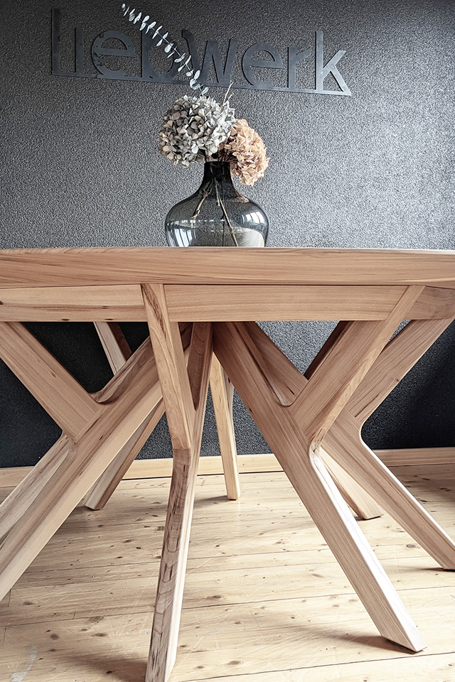 Runder Holztisch mit tollem Inselgestell von Liebwerk für ein natürliches Wohnambiente.