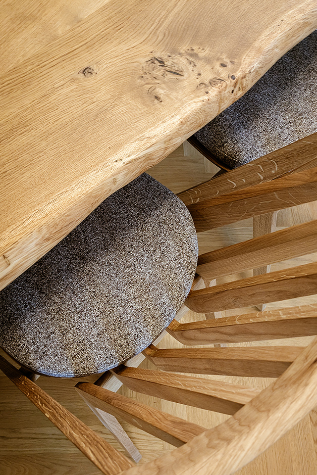 Den Baumkantentisch aus Eiche gibt es mit passendem Holzstuhl und individuell gefertigter Polsterauflage von Möbelschreinerei Liebwerk