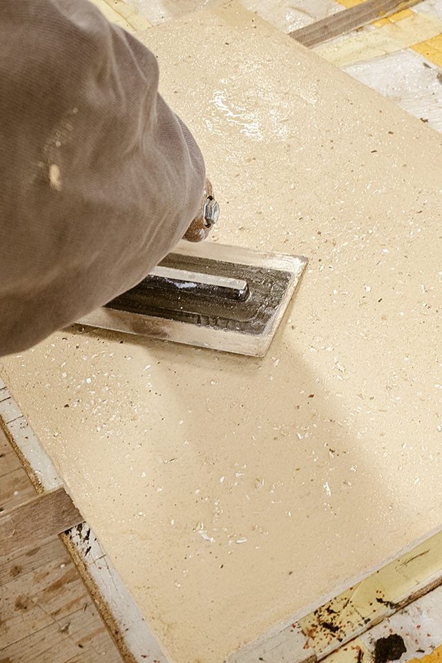 An einem Musterbrett entstehen die ersten Versuche zur Oberflächenstruktur von Mikrozement im Workshop Beton und Objekt bei Schreinerei Liebwerk am Bodensee.